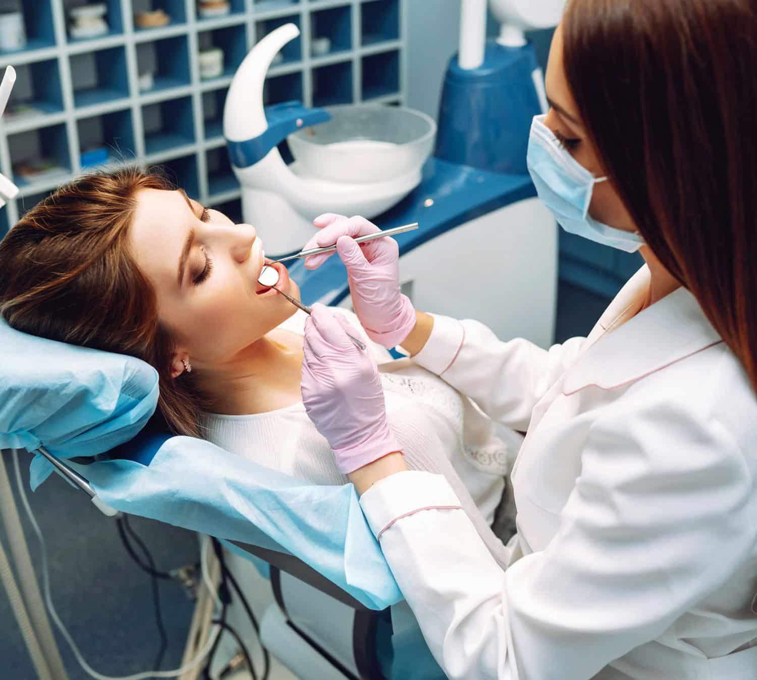 Female patient with open month and dentist doing a procedure