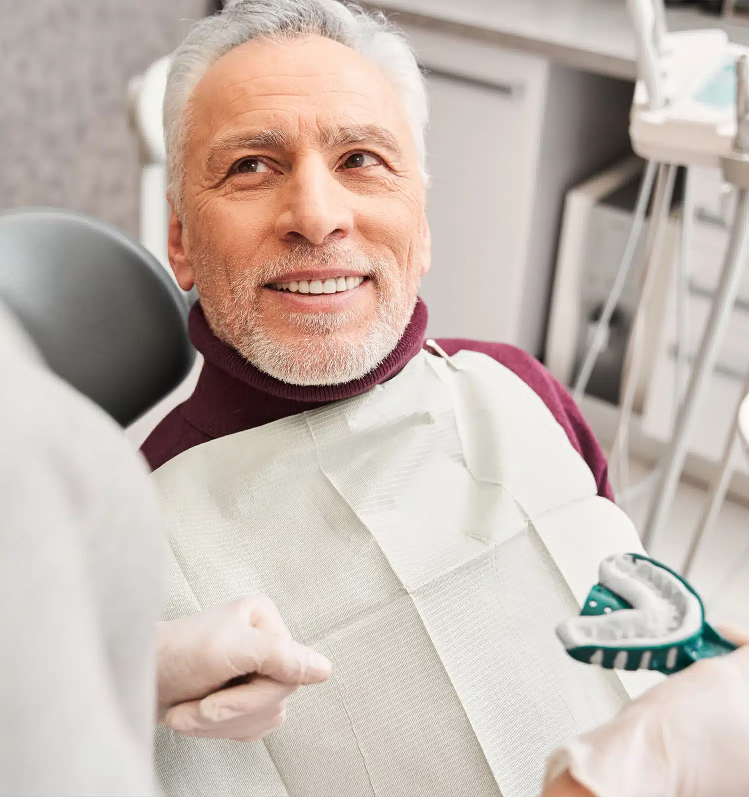 Smiling male patient at dentist chair
