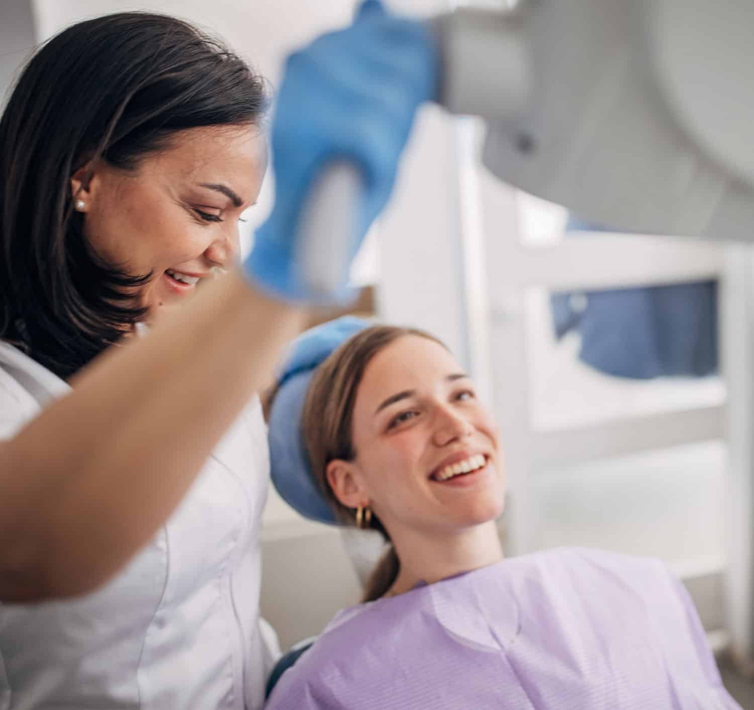 Smiling female patient at dentist chair