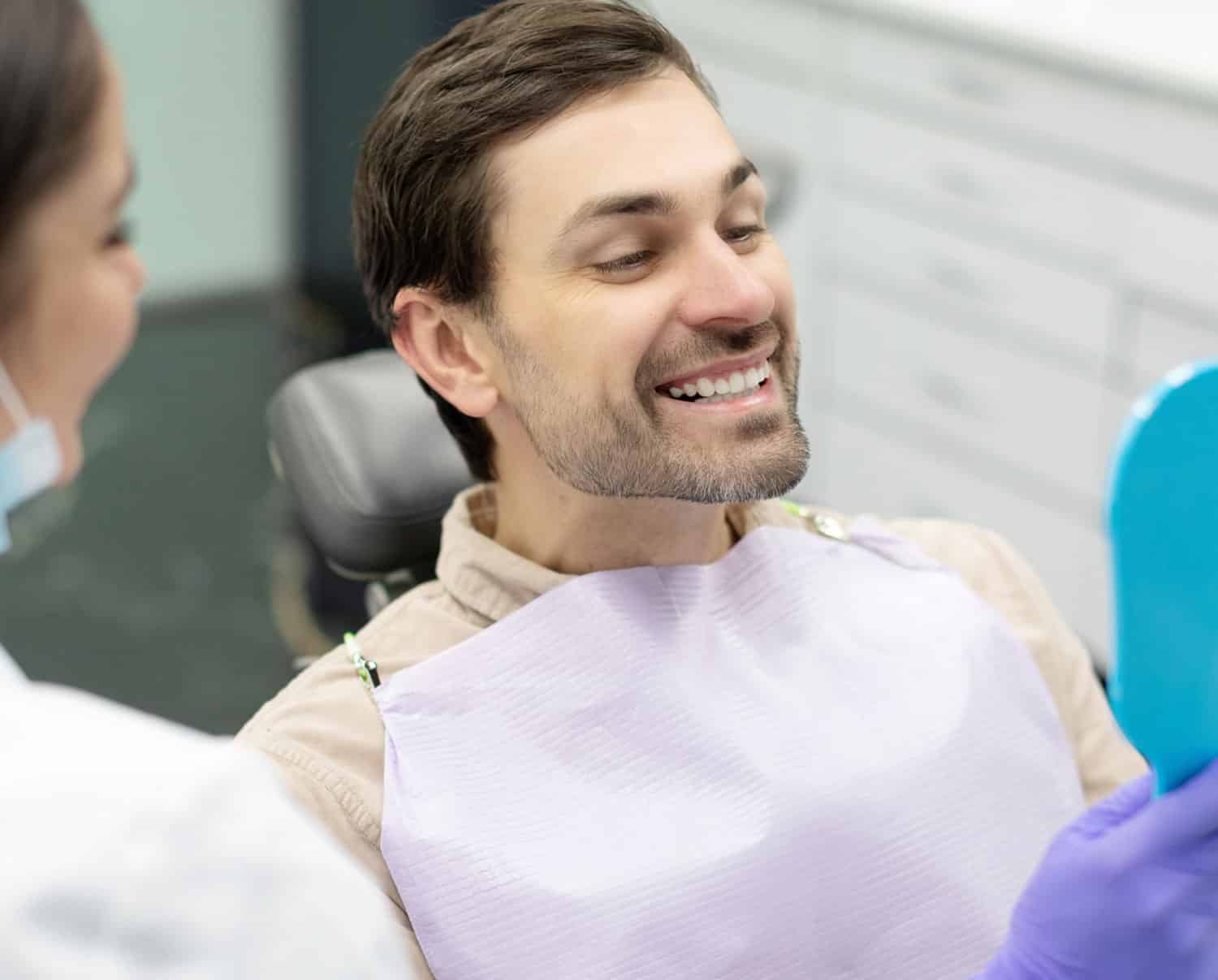 Smiling patient looking at the mirror