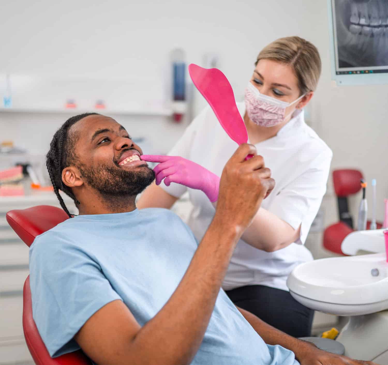 Joyful male is lying in chair and looking into mirror while being delighted with dentist work